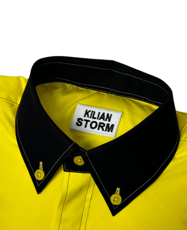 a yellow shirted pillow with a black collar and label