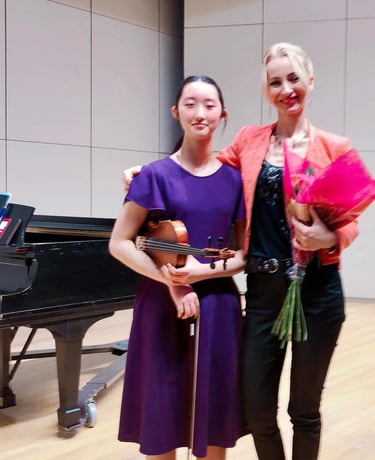 Violin student with her violin teacher after a successful recital