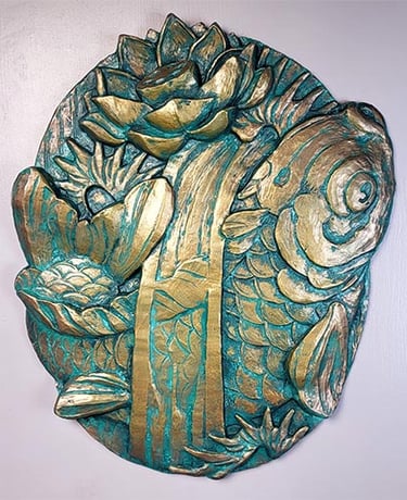 A plaque in the style of traditional tattoo art. it shows a Koi fish surrounded by waves and a lotus