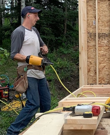 Image of Niko, a tall white male, holding a framing gun.