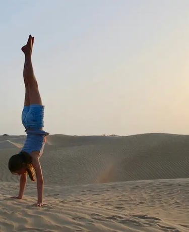 A woman doing a handstand in the desert