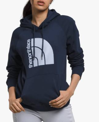 a woman in a blue hoodie and white pants