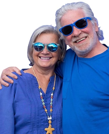 Smiling senior couple wearing sunglasses, embracing and looking happy and confident