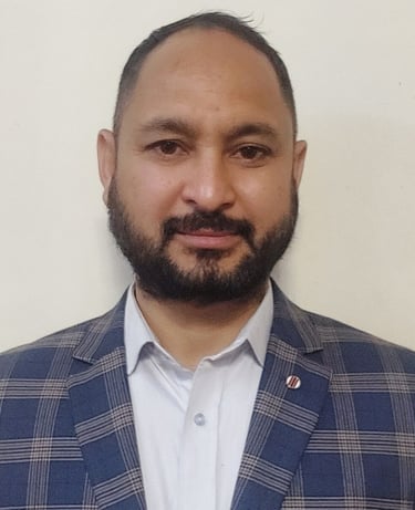 A bearded man in a blue jacket, a Principal and ex-service man, well qualified and knowledgeable.
