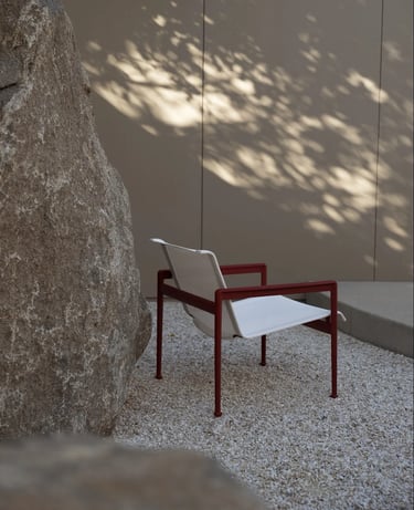 Outdoor lounge seating with armchairs, hanging chair, soft cushions and natural textures for relaxed