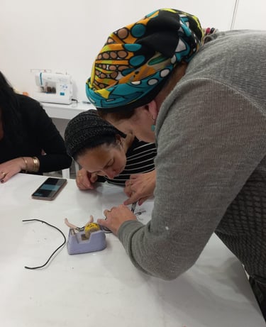 An instructor helping a participant with metal line artwork