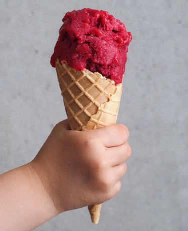 sorbet rabarbarowy w rożku trzymany przez dziecko