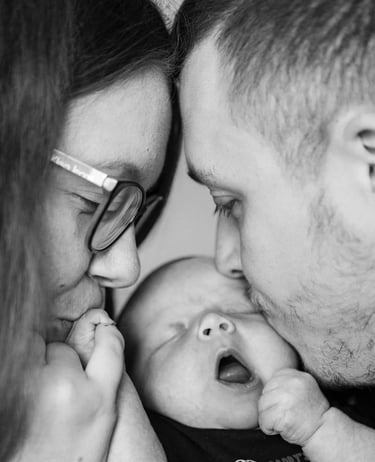 Deux parents faisant un bisou à leur bébé