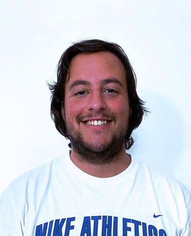 Rafael Botelho with a beard smiling while wearing a white t-shirt