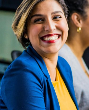 a woman sitting at a desk with a man and woman