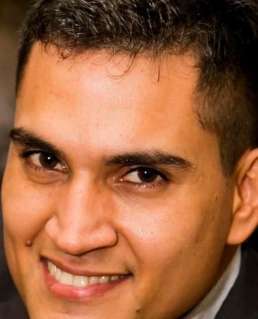 a man in a suit and tie is pointing at the camera