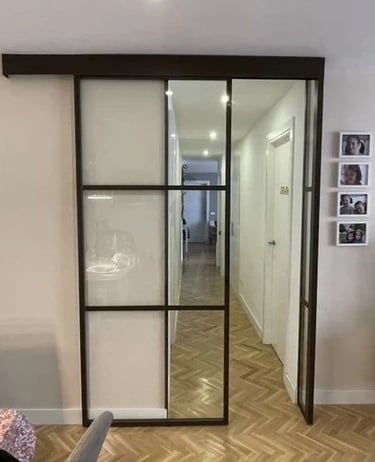 Puerta de interior corredera de una hoja en hierro con cuarterones.