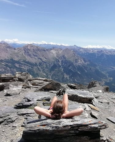 a woman laying on a rock in the mountains