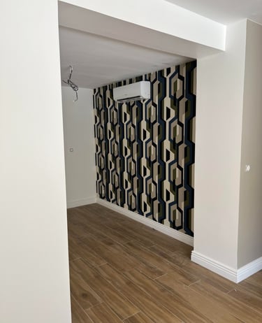 a room with a wallpapered wall and a wooden floor