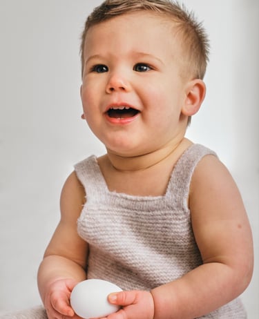 a baby is smiling and holding a white object