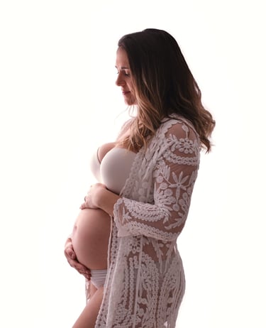 a pregnant woman in a white lace robe and a white robe