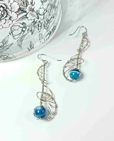 Steel earrings of curls amd weave, with blue agate beads within