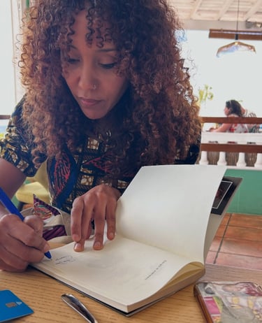 una mujer afro escribiendo en un libro