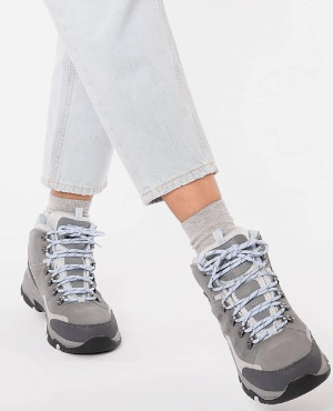 a woman's feet in grey shoes with laces