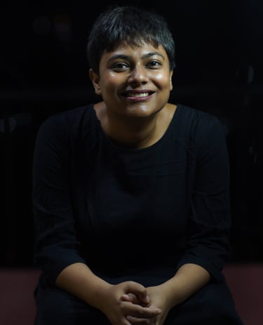 This is an image of the therapist. With a black background and clothing, a wide welcoming smile