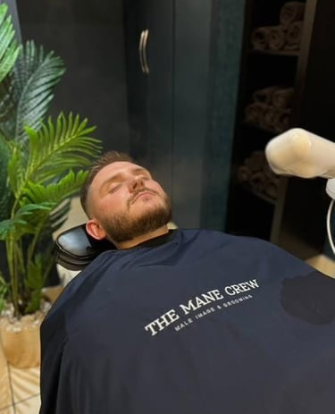 Man lying on a barber shair at the mane crew barbers