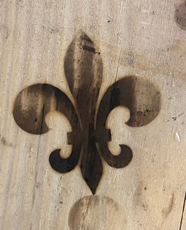 burned fleur de lis symbol into a piece of wood