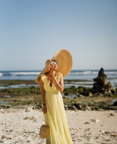 Portrait of woman standing on beach wearing wide sun hat at Melasti Beach Bali