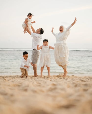 Joyful family moment captured at Melasti Beach Bali with parents and children running on the sand