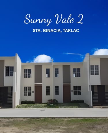 Modern white and brown townhouses at Sunny Vale 2 in Sta. Ignacia, Tarlac under a bright blue sky.