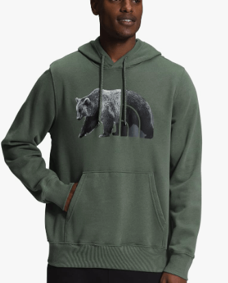 a man in a green hoodie with a bear in the background