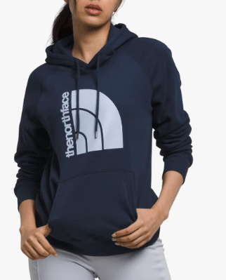 a woman in a blue hoodie and white pants