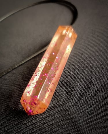 a pink and gold necklace with a pink and pink glitter