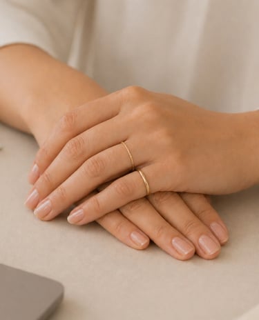 Minimal hand jewelry with simple gold ring and thin band on natural nails