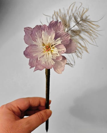 LYSENN PARIS a person holding a flower with feathers
