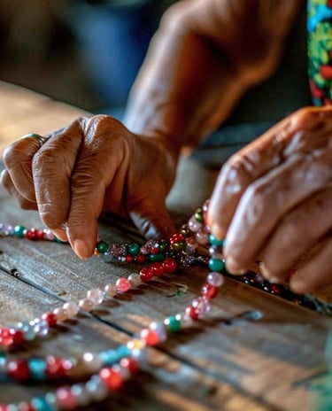 Las manos de un artesano elaborando cuidadosamente un collar artesanal de cuentas de colores.