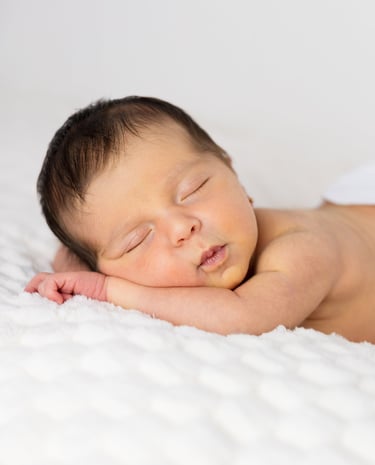 Sessió de fotos newborn a Girona amb una bebè recent nascuda dormint en estudi fotogràfic