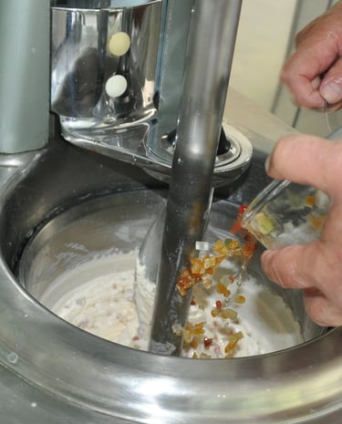 Nos artisans glacier mélangeant les fruits confits d'Apt et le Kirsch avec la crème glacé