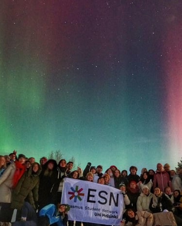 a group of people standing in front of a green and purple sky