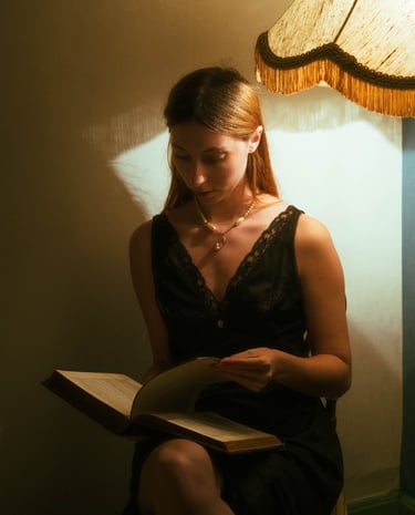 Autoportrait d'une femme avec un livre dans la pénombre