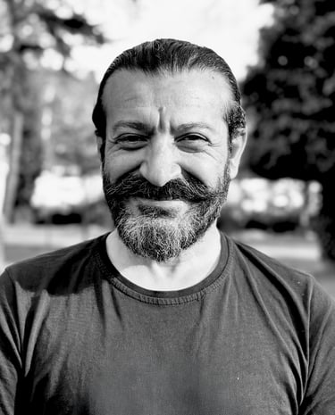 Mehmet Başkak, Tai Ji and Wudang Sword instructor of WDP Turkey, smiling outdoors in black shirt.