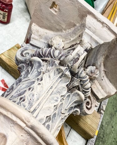 A Victorian metal column's capital painted in faux sandstone.