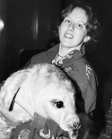 a woman holding a grey seal pup