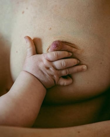 main de bébé sur un sein