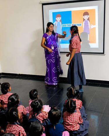 Teacher conducting an interactive smart classroom session with primary school students at Little Cub