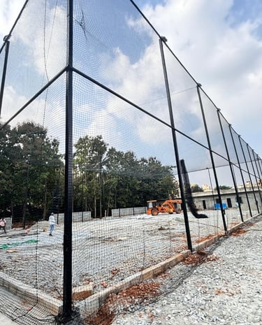 Technician from Arjilli Enterprises carefully installing a safety net on a balcony railing.