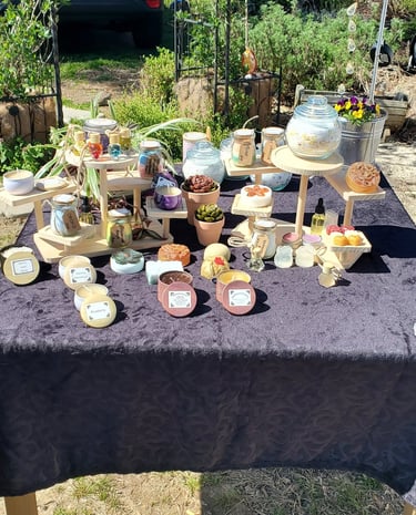 Handmade Organic Beeswax candles and artisan soaps displayed on wooden stands.