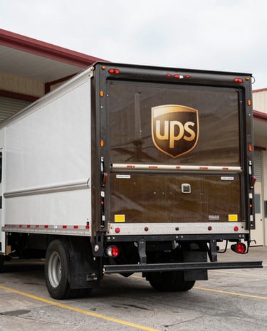 Friendly staff assisting a customer at the shipping counter filled with packages.