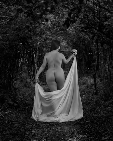 A naked woman in a white dress with a skull on her hand.