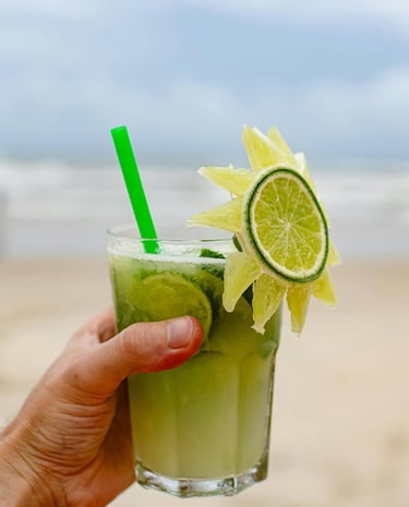 a person holding a drink in a glass, Caipirinha, In Copacabana Beach, Rio de Janiero, Brazil