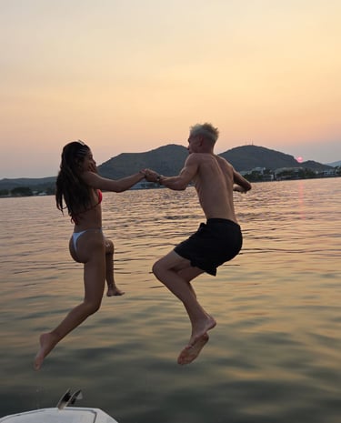 un couple de jeunes sautant dans la mer main dans la main